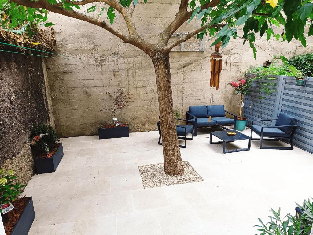 a patio with two chairs and a tree at Charmante maison de ville in Lyon