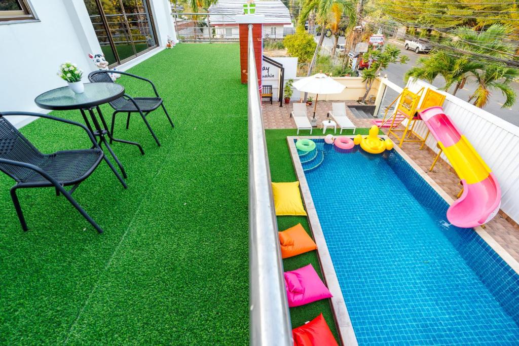 une arrière-cour avec une piscine avec un toboggan et une table dans l'établissement ไอทะเล พูลล่า หัวหิน I-Talay Poolvilla huahin, à Hua Hin