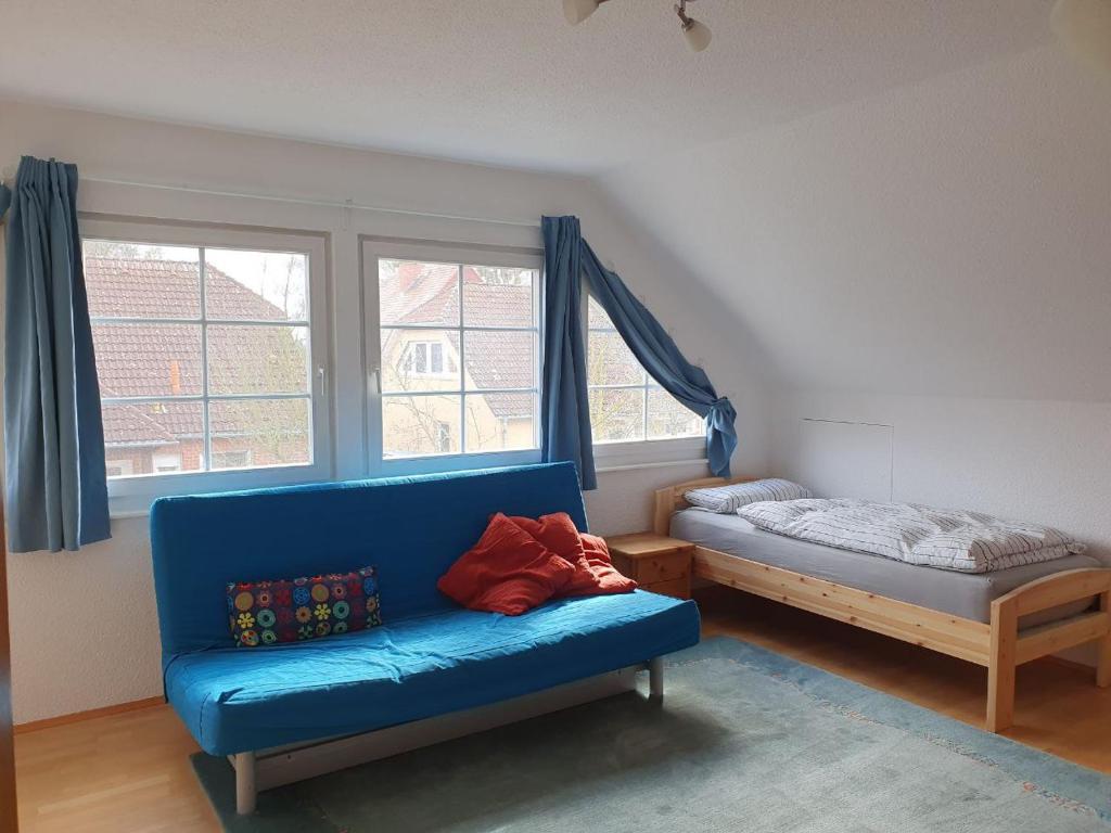 ein Wohnzimmer mit einem blauen Sofa und einem Bett in der Unterkunft Gemütliche Ferienwohnung in Potsdam