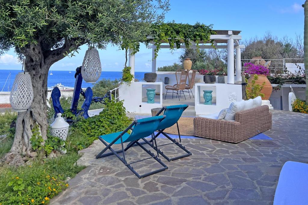 - un ensemble de chaises et de chaises assises sur une terrasse dans l'établissement Dependance La Caletta, à Panarea