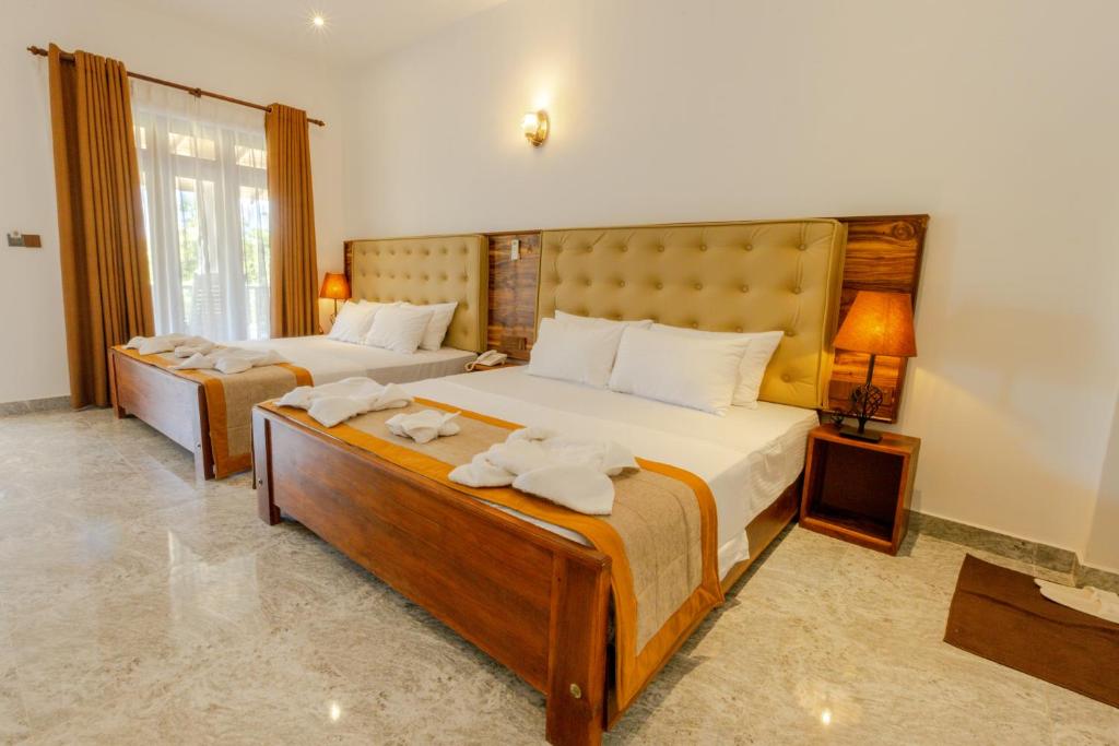 Postel nebo postele na pokoji v ubytování Elysia Sigiriya Hotel