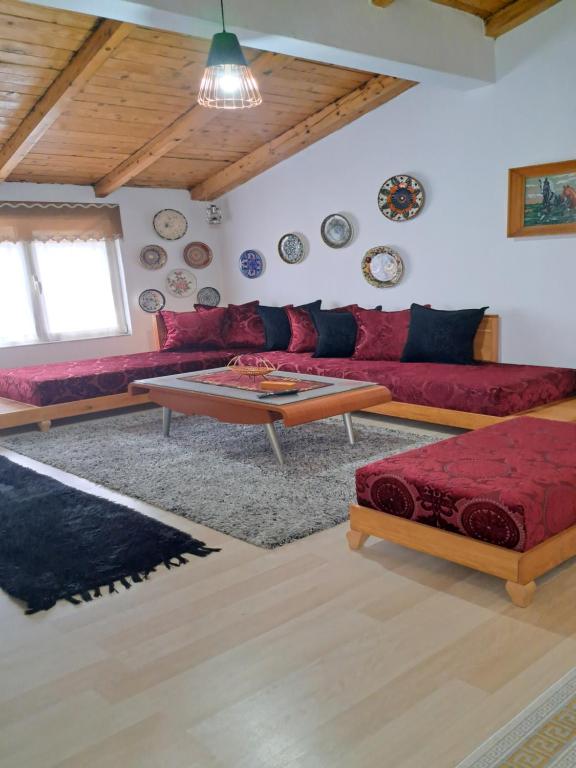 a living room with a red couch and a table at The house of dreams in Shkodër