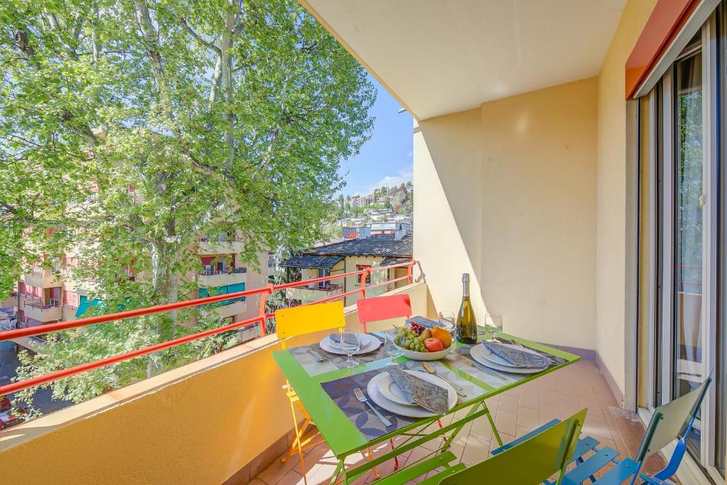 a table and chairs on a balcony with a bottle of wine at Casa Palma - Happy Rentals in Lugano