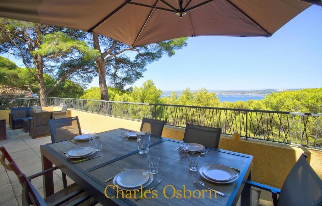 een blauwe tafel met stoelen en een parasol op een balkon bij Stoneview Villa in Sète