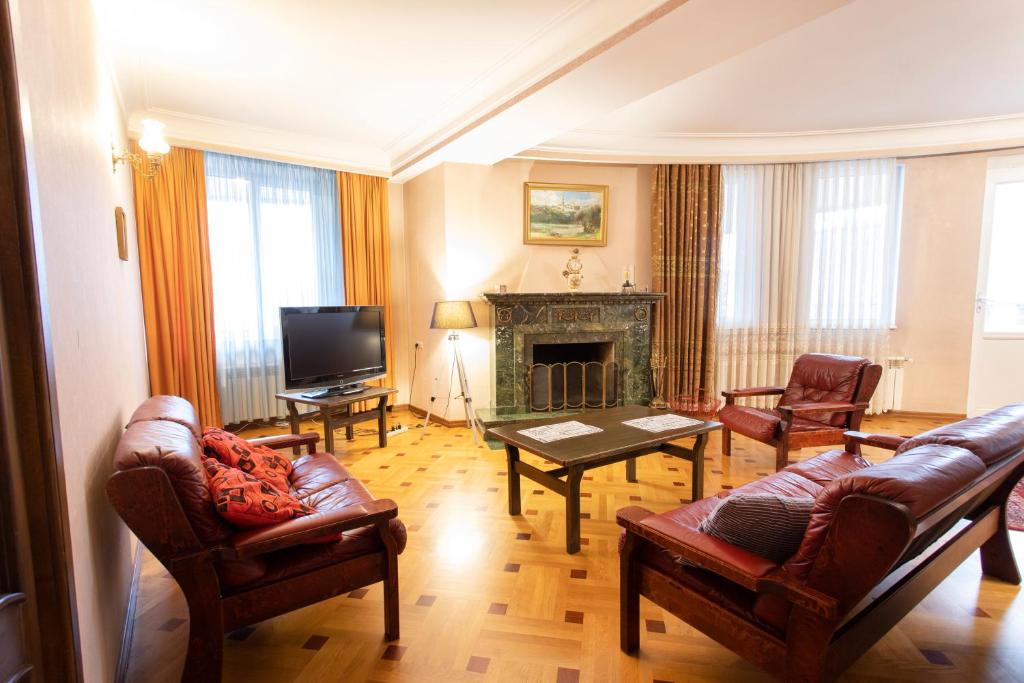 ein Wohnzimmer mit Ledermöbeln und einem Kamin in der Unterkunft Suite Penthouse 55 in Tbilisi City