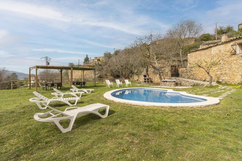 un gruppo di sedie e una piscina in un cortile di Cal Sastre a Biscarri