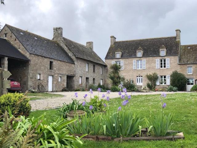 una vieja casa de piedra con flores en el patio en LA FERME DE NEHOU en Gatteville-le-Phare