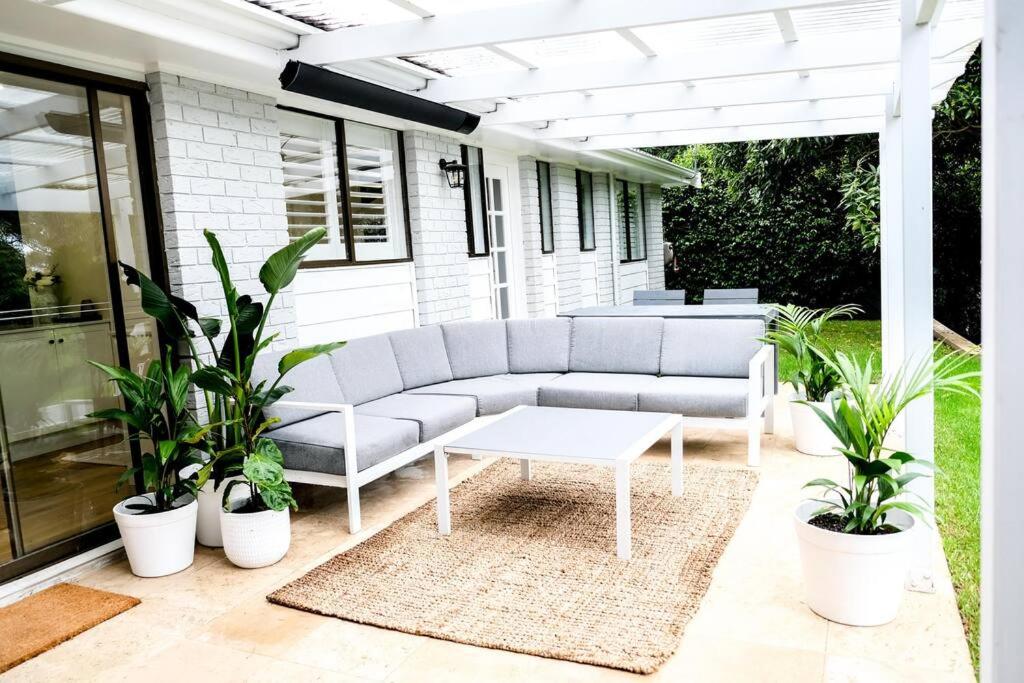 a couch sitting on a patio with plants at Henderson House in Wentworth Falls