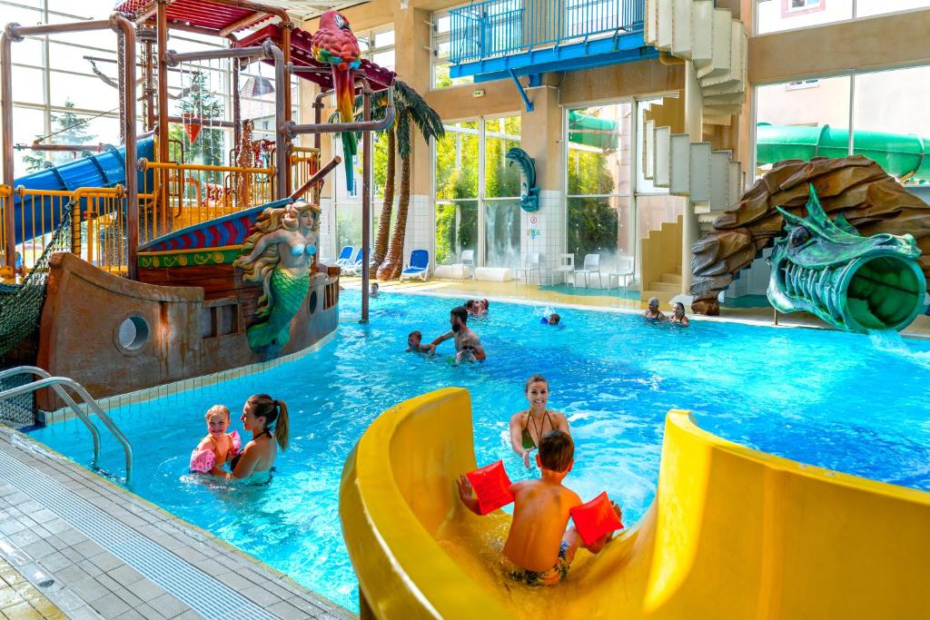 een groep mensen in een zwembad bij een waterpark bij Explorers Hotel Marne-la-Vallée in Magny-le-Hongre