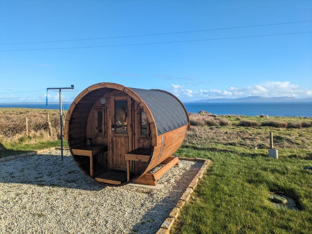 una piccola casa hobbit di legno seduta sull'erba di Vista Mara a Donegal