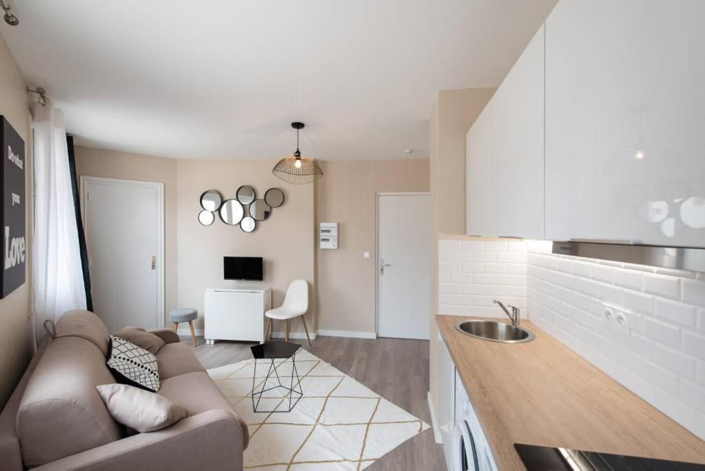 a living room with a couch and a kitchen at Appartement Passion - moderne et lumineux AIL in Lyon