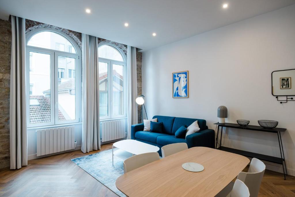 a living room with a blue couch and a table at All in Lyon | T2 design & climatisé – Centre in Lyon