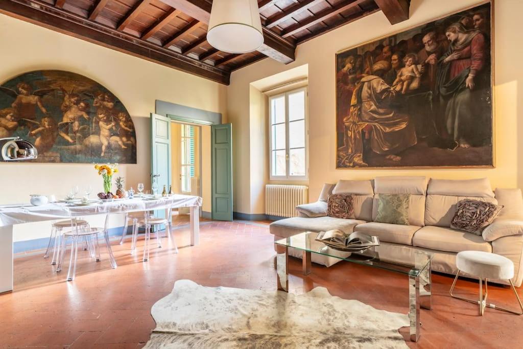 una sala de estar con sofá y una pintura en la pared en Ginny’s house- Borgo la croce luxury apartment, en Florencia