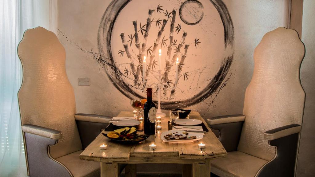 a table with a plate of food and candles on it at Hotel Butterfly in Torre del Lago Puccini