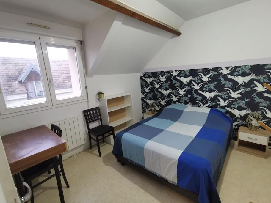 une chambre avec un lit, un bureau et une chaise dans l'établissement Le cozy, à Sartrouville