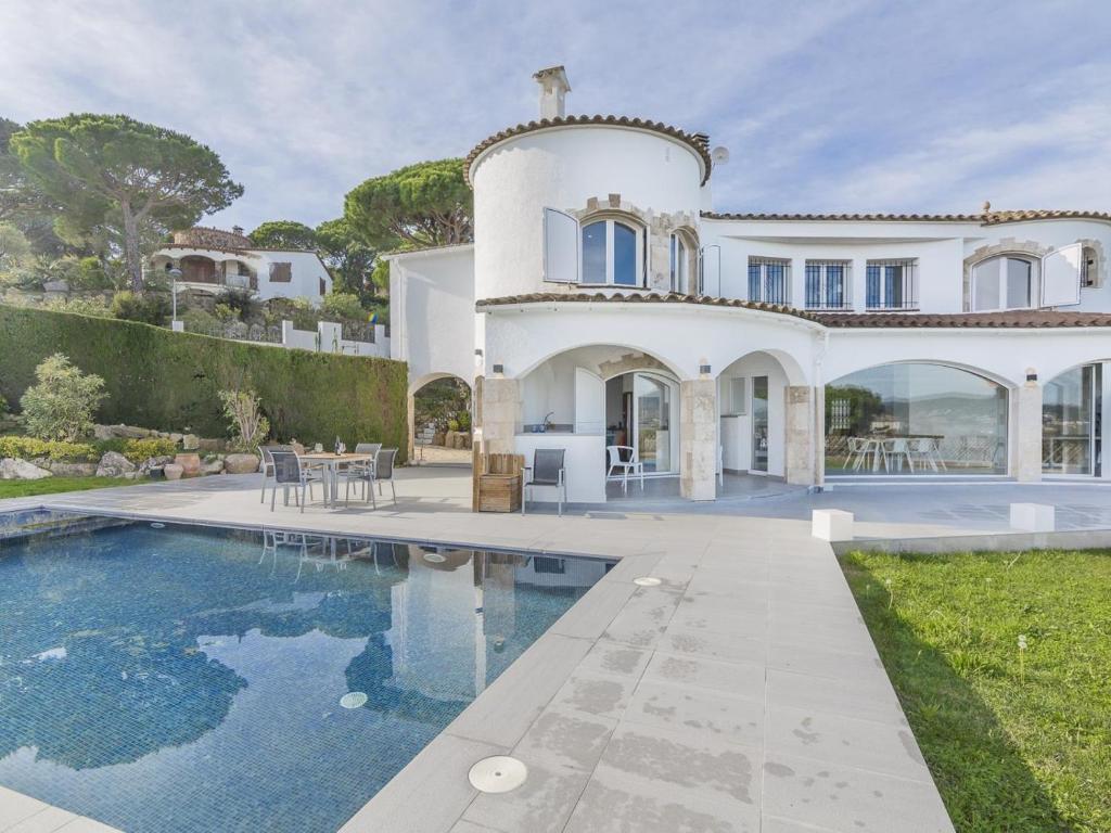 an exterior view of a villa with a swimming pool at Villa Saramel con vistas panorámicas al mar in Sant Antoni de Calonge