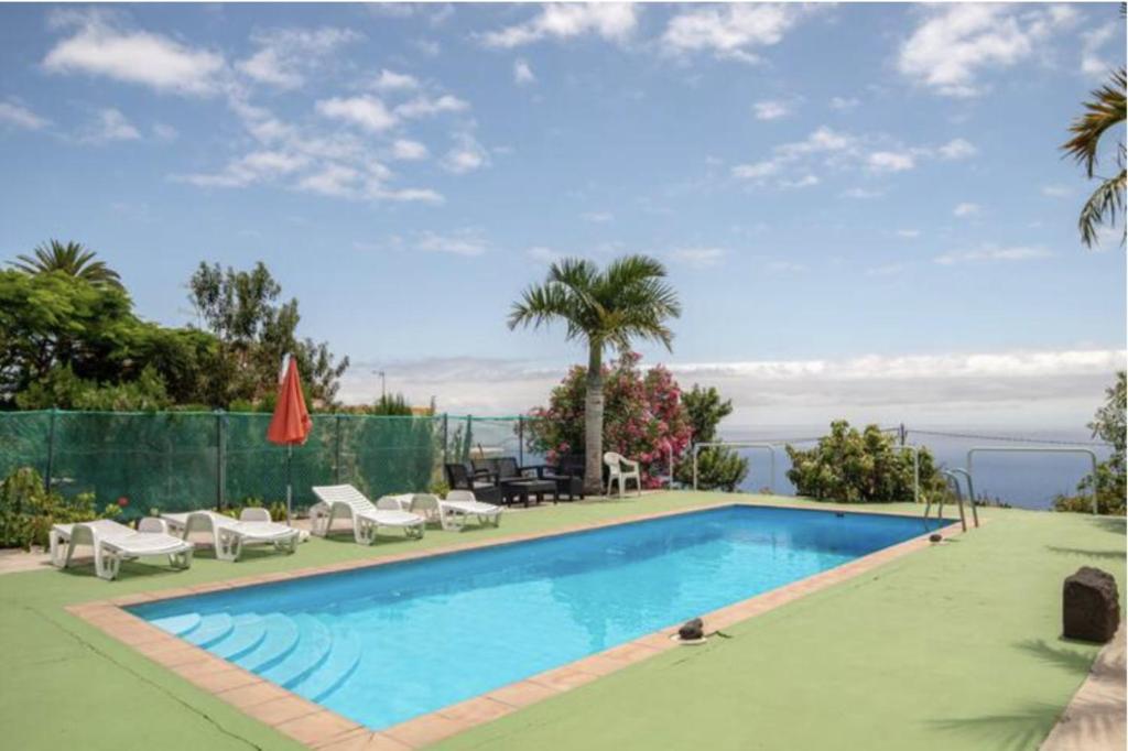 ein Pool mit Liegen und Stühlen neben in der Unterkunft Lightbooking Luymar Villa de Mazo con piscina in Mazo