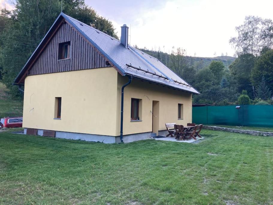 uma casa grande com um telhado de metal num campo em Chata Holčovice em Nová Komora
