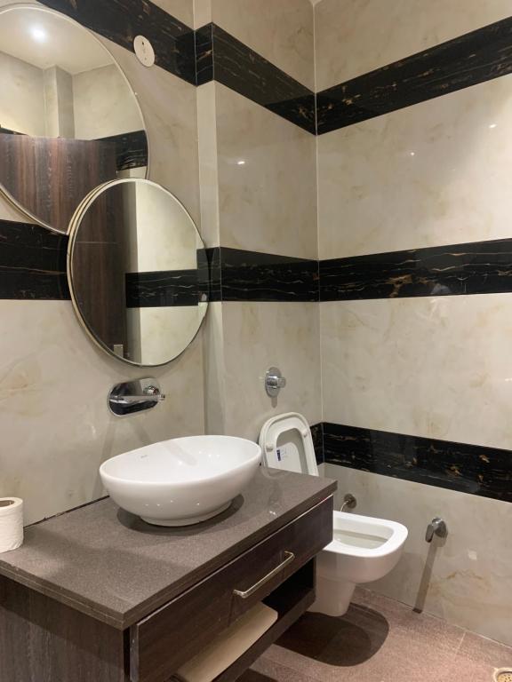 a bathroom with a sink and a toilet and a mirror at Hotel New BMS pride in Amritsar