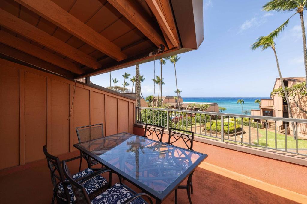 een tafel en stoelen op een balkon met uitzicht op de oceaan bij Kuleana Resort 207 in Kahana