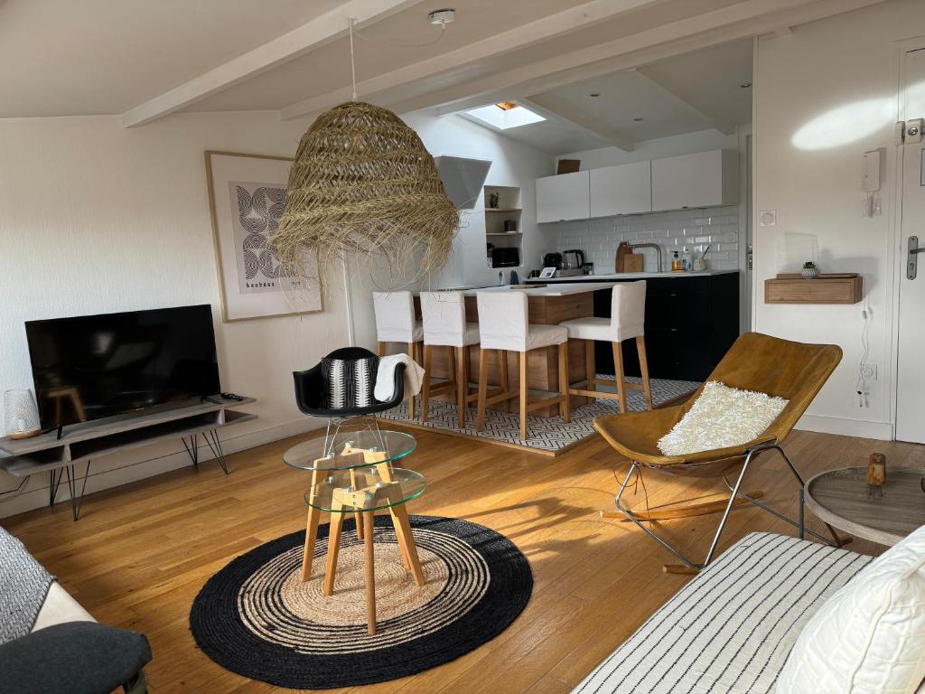 ein Wohnzimmer mit einem Sofa und einem Tisch mit Stühlen in der Unterkunft ღ La Cabane Rochelaise • Vue sur le vieux-port in La Rochelle