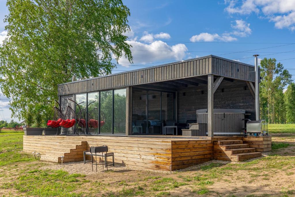 a house with a barbecue in a field at Doles Perle in Ķekava