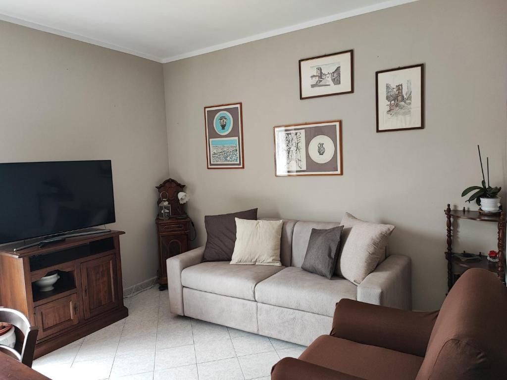 uma sala de estar com um sofá e uma televisão de ecrã plano em Come a casa em Monsummano