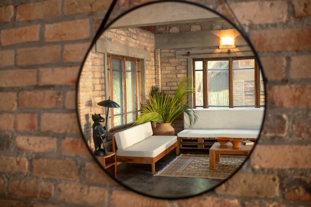 espejo que refleja una sala de estar con sofá y silla en Inhambane Bay View Home, en Inhambane