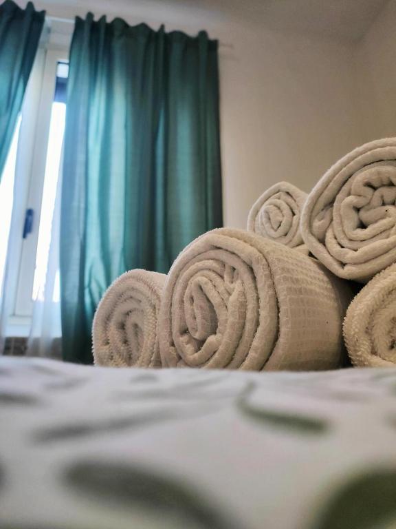 een stapel handdoeken bovenop een bed bij Bilocale 5 a pochi passi da Milano in Sesto San Giovanni