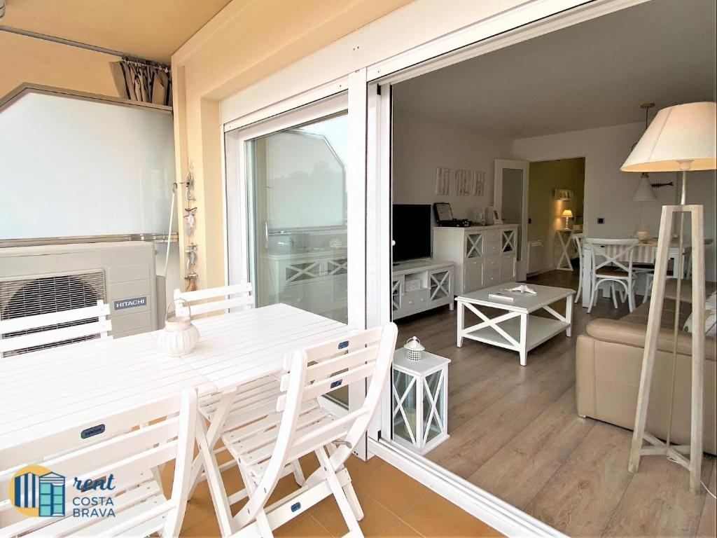 een woonkamer met een witte tafel en stoelen en een kamer bij Apto bluedream in S'Agaro