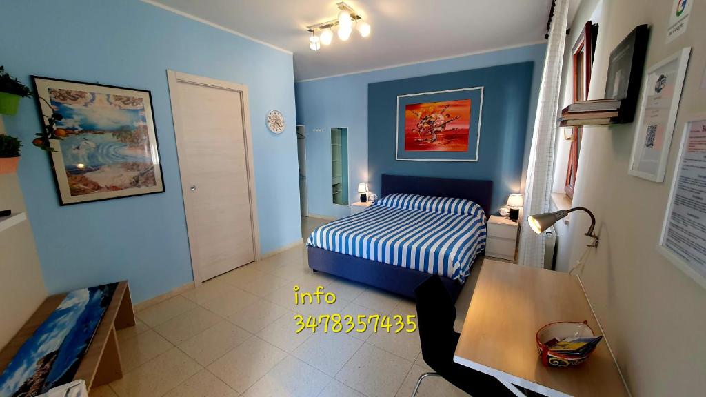 a small bedroom with a bed and blue walls at Scilla Guest House in Scilla