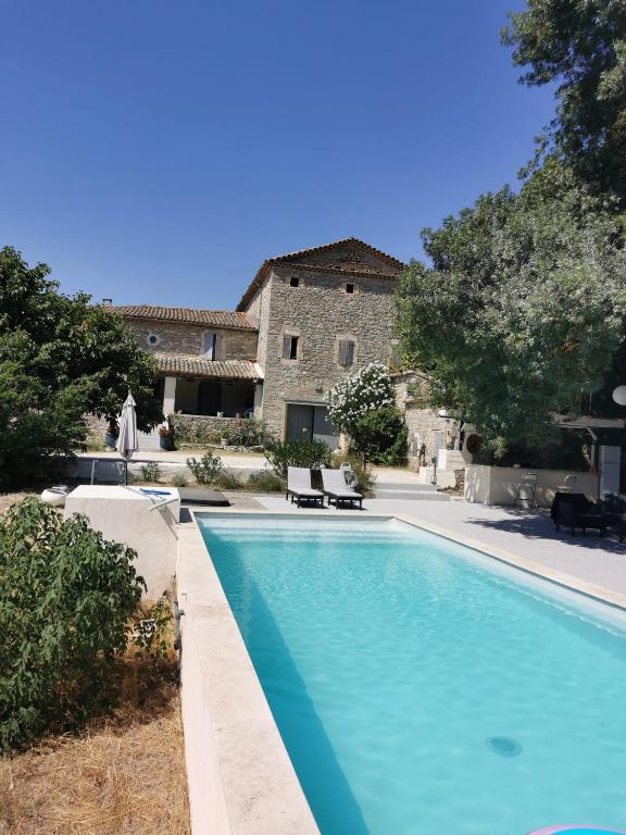 une grande piscine devant un immeuble dans l'établissement Le Mas Neuf des Greses, à Canaules-et-Argentières