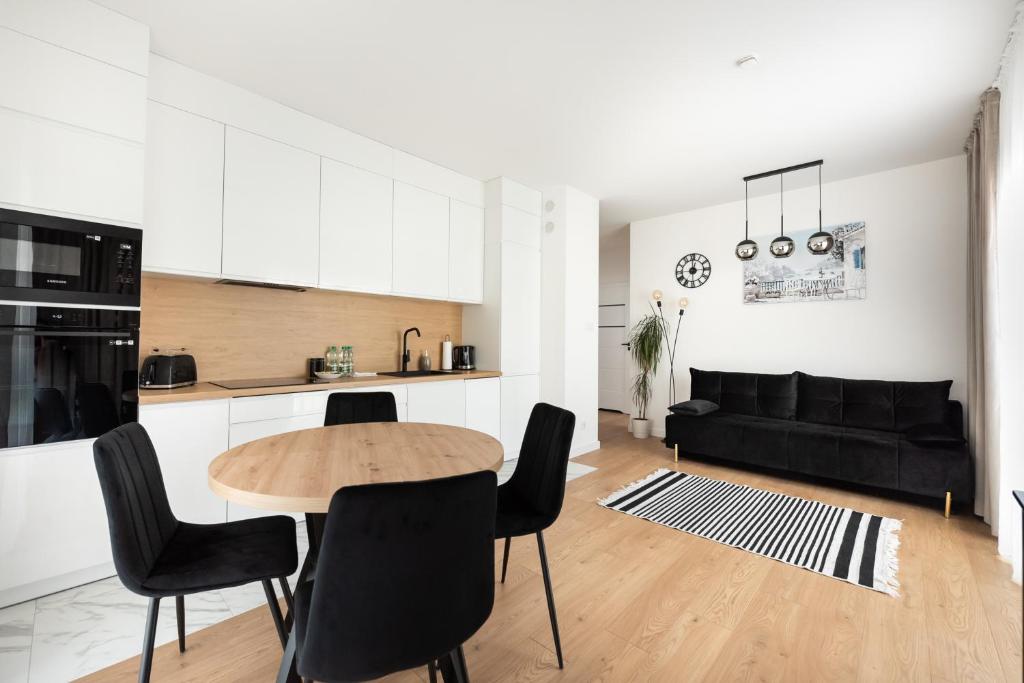a kitchen and living room with a table and chairs at Brzeziny Deluxe Apartment in Warsaw