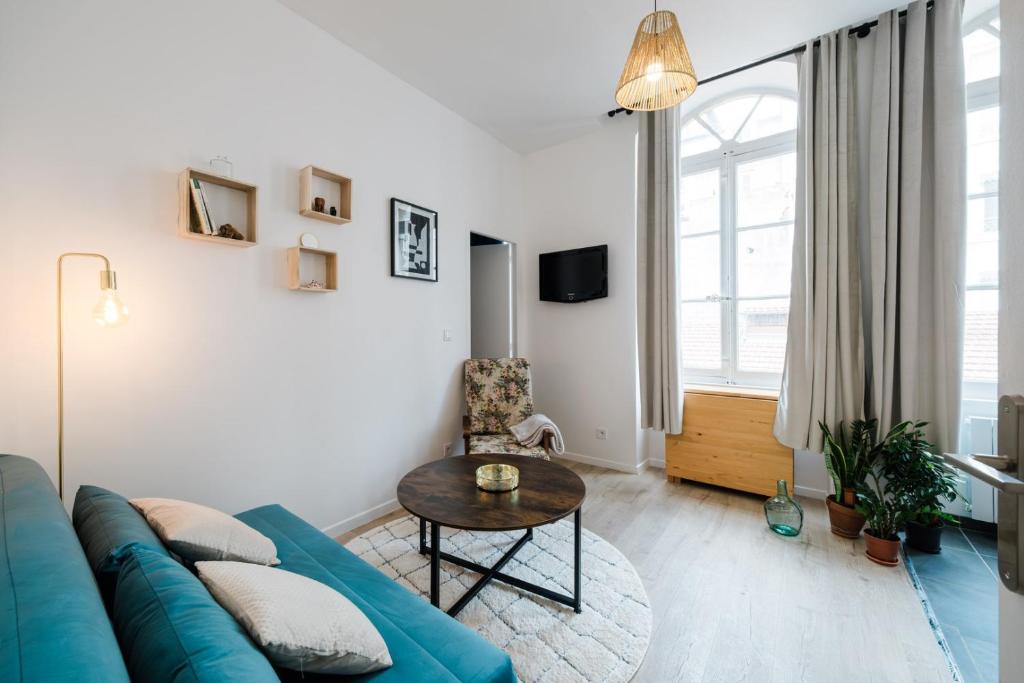 een woonkamer met een blauwe bank en een tafel bij Bright, relaxing city-centre apartment AIL in Lyon