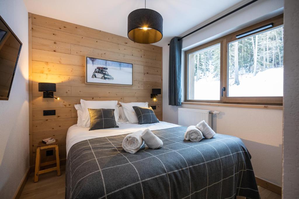 a bedroom with a bed with towels on it at Snoroc by Daddy Pool- TERRESENS in Aime La Plagne