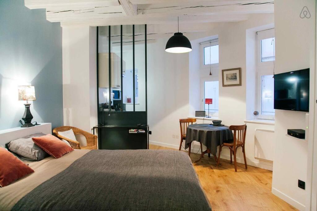 a bedroom with a bed and a table and chairs at Saint-Paul Vieux Lyon - parking included in Lyon