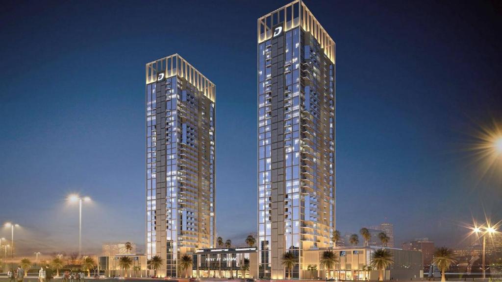 Due grattacieli alti in una città di notte di DAMAC Maison Prive In Business Bay a Dubai