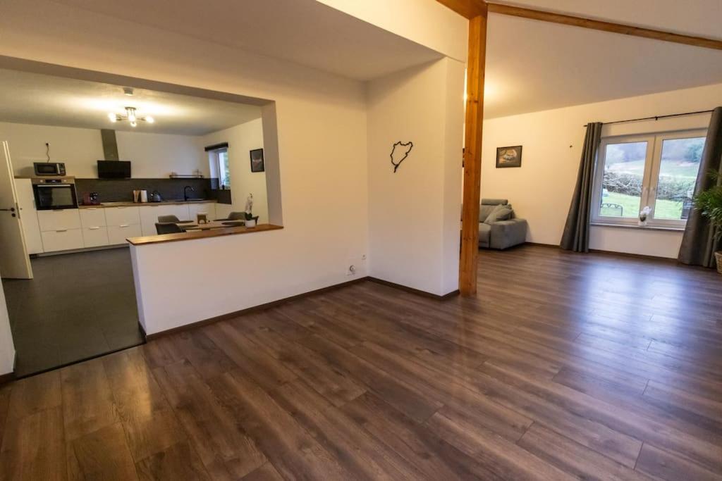 una sala de estar vacía con suelo de madera dura en Südschleife Apartments - App. 3 - Direkt am Ring, en Reimerath