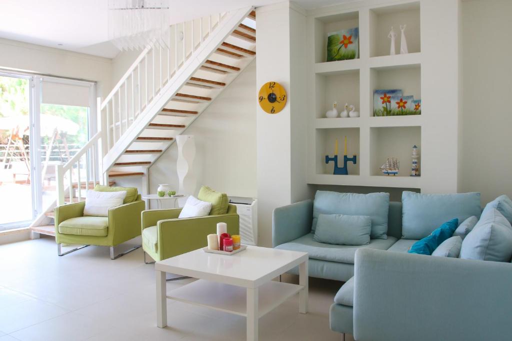 sala de estar con escaleras y muebles de color azul y verde en Villa Sun, en Golem