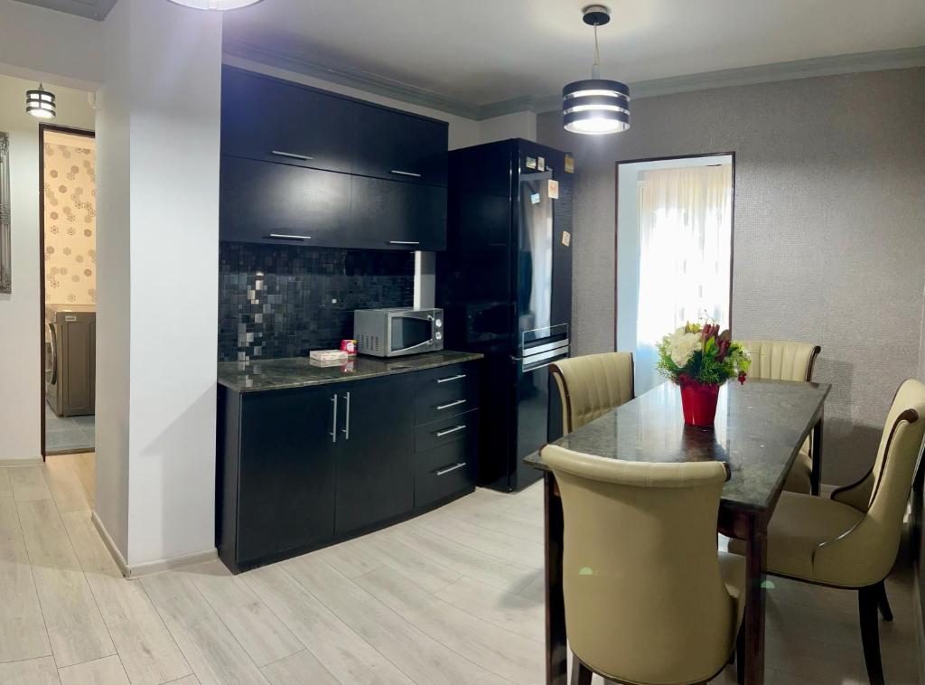 a kitchen with black cabinets and a table with chairs at Lion House in Drobeta-Turnu Severin