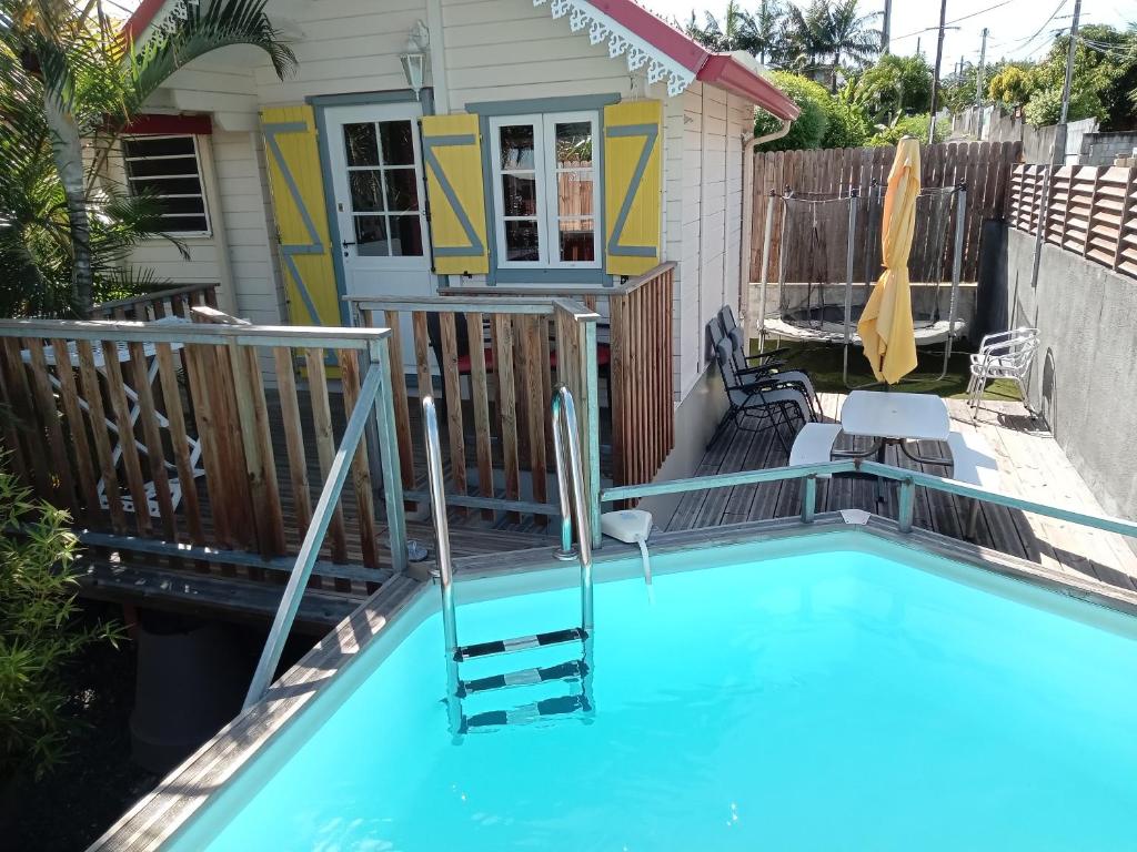 una casa con piscina en el patio en Bungalow des papayes, en Saint-Louis