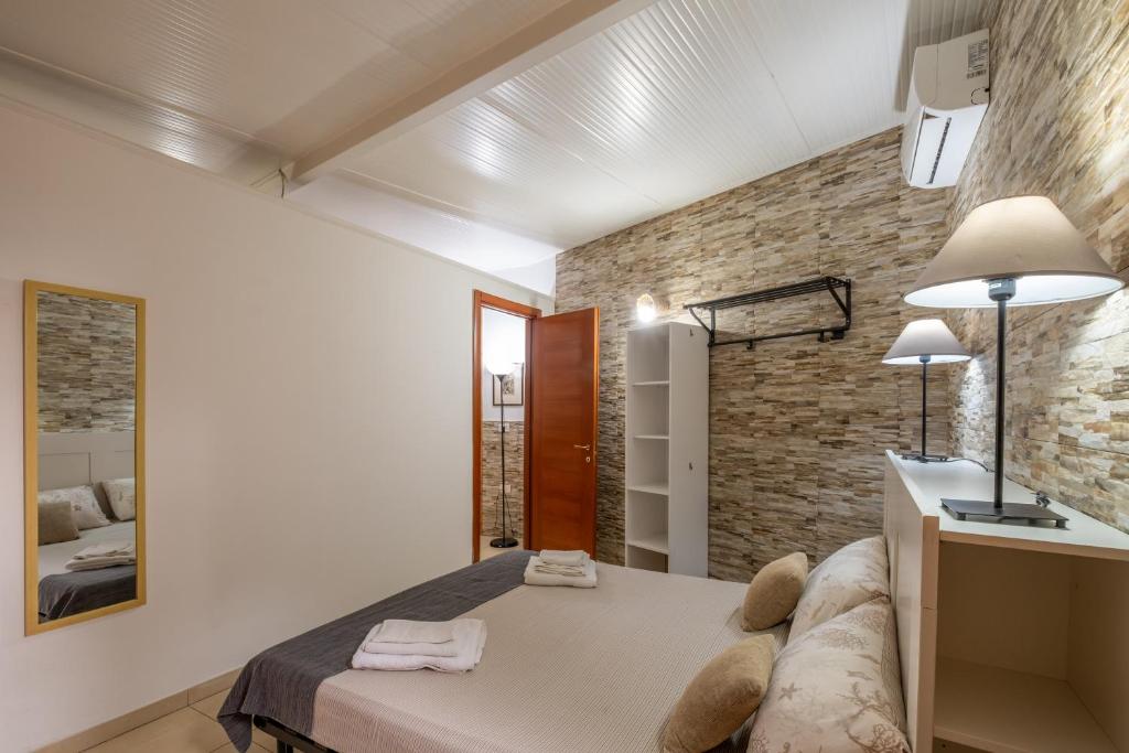 a bedroom with a bed and a brick wall at Villa Gaudì - Batllò in Sant'Isidoro