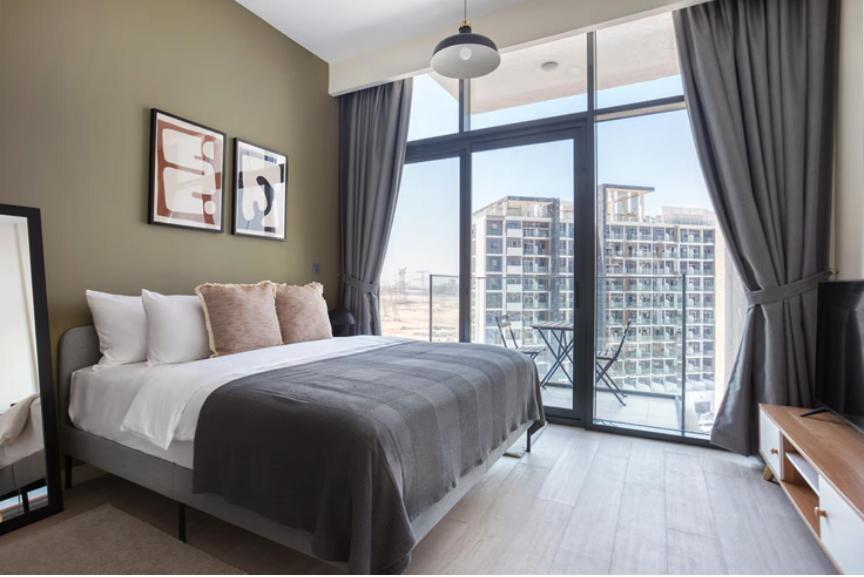 a bedroom with a bed and a large window at Azizi Riviera Small Family Private Apartment Dubai in Dubai