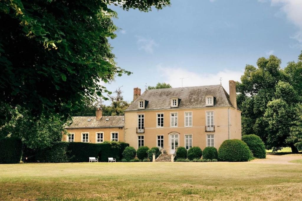 ein großes Haus mit einem großen Grasfeld in der Unterkunft Château de Marigné - Gîte de charme- 15 pl in Cré-sur-Loir