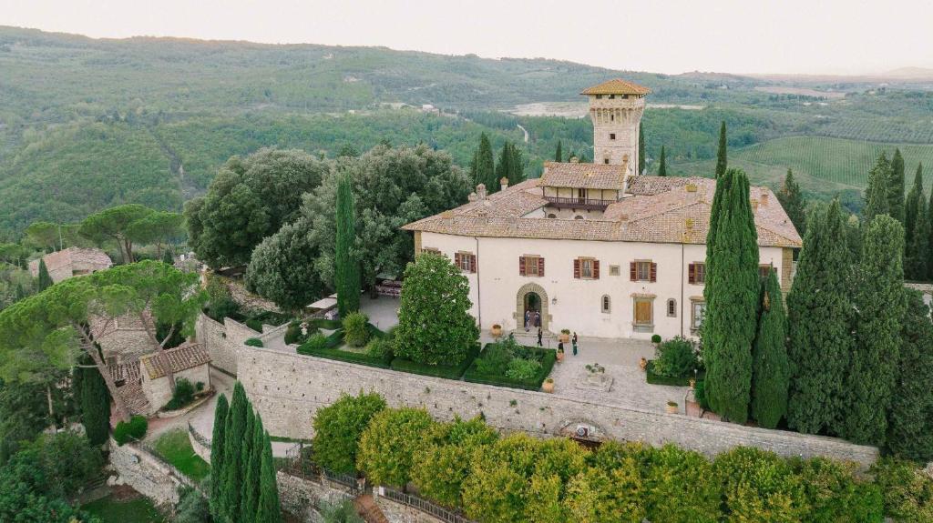 une vue aérienne sur un bâtiment avec une tour dans l'établissement Castello Vicchiomaggio, à Greve in Chianti