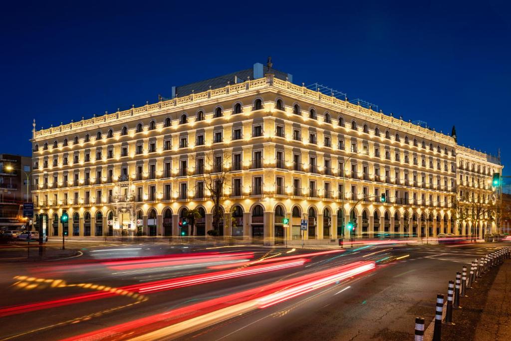 um grande edifício branco com tráfego em frente em Exe Sevilla Macarena em Sevilha