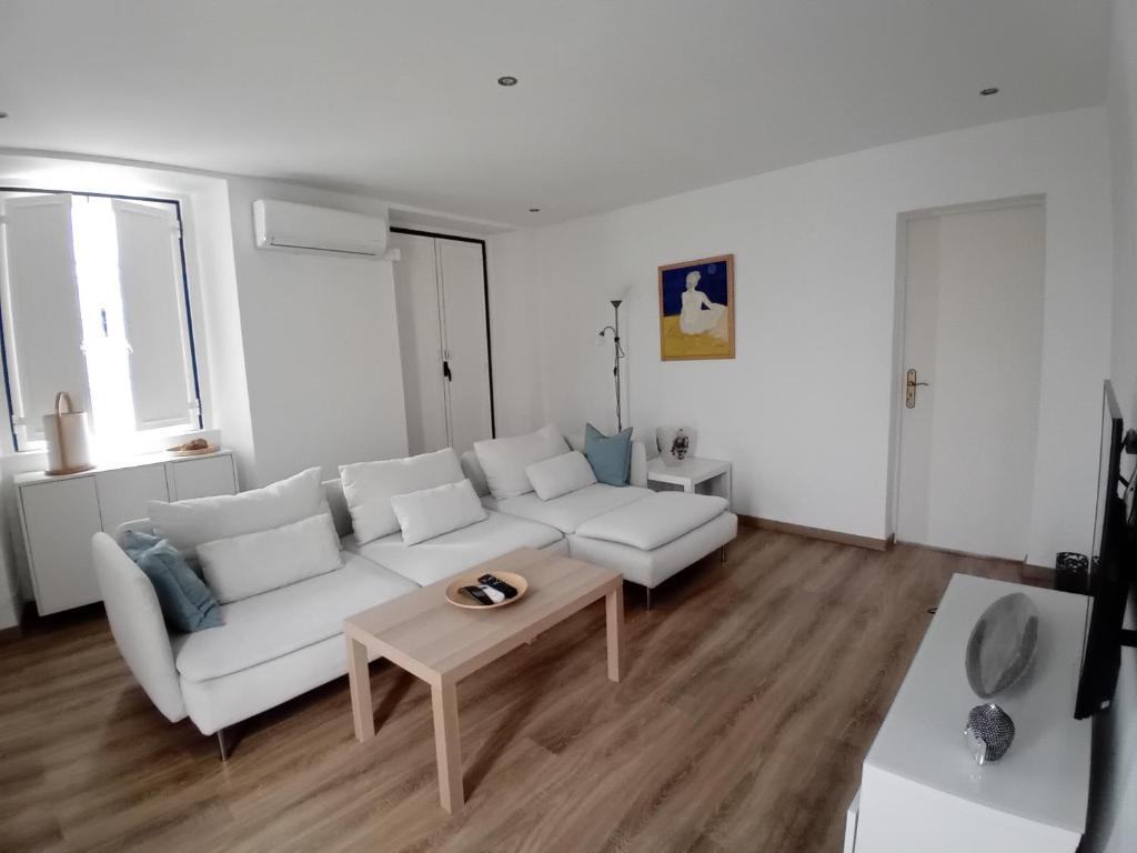 ein Wohnzimmer mit einem weißen Sofa und einem Couchtisch in der Unterkunft Casa do Coronel in Alcochete