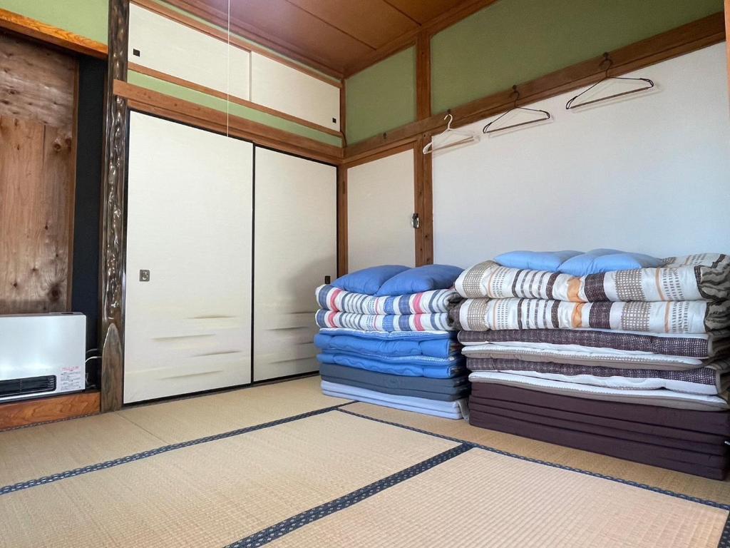 um quarto com duas portas de garagem e uma pilha de cobertores em 農家古民家ねこざえもん奥屋敷 Nekozaemon-Gest house em Nishiwada