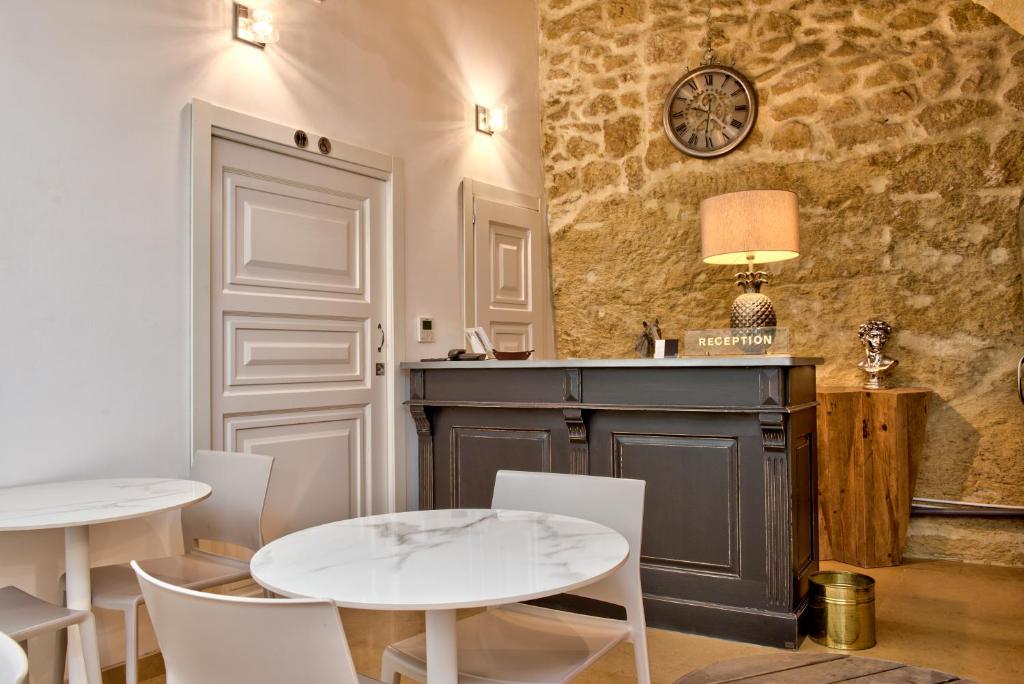 una sala da pranzo con due tavoli e sedie bianche di 50th Guest House a Vittoriosa