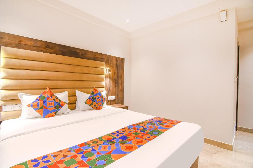 a bedroom with a large white bed with colorful pillows at FabHotel Prime The Pavilion in kolkata